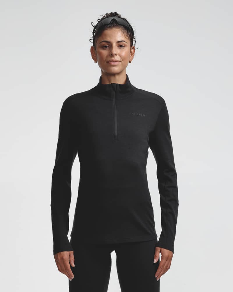 Dæhlie female model wearing black half-zip baselayer top, front view.