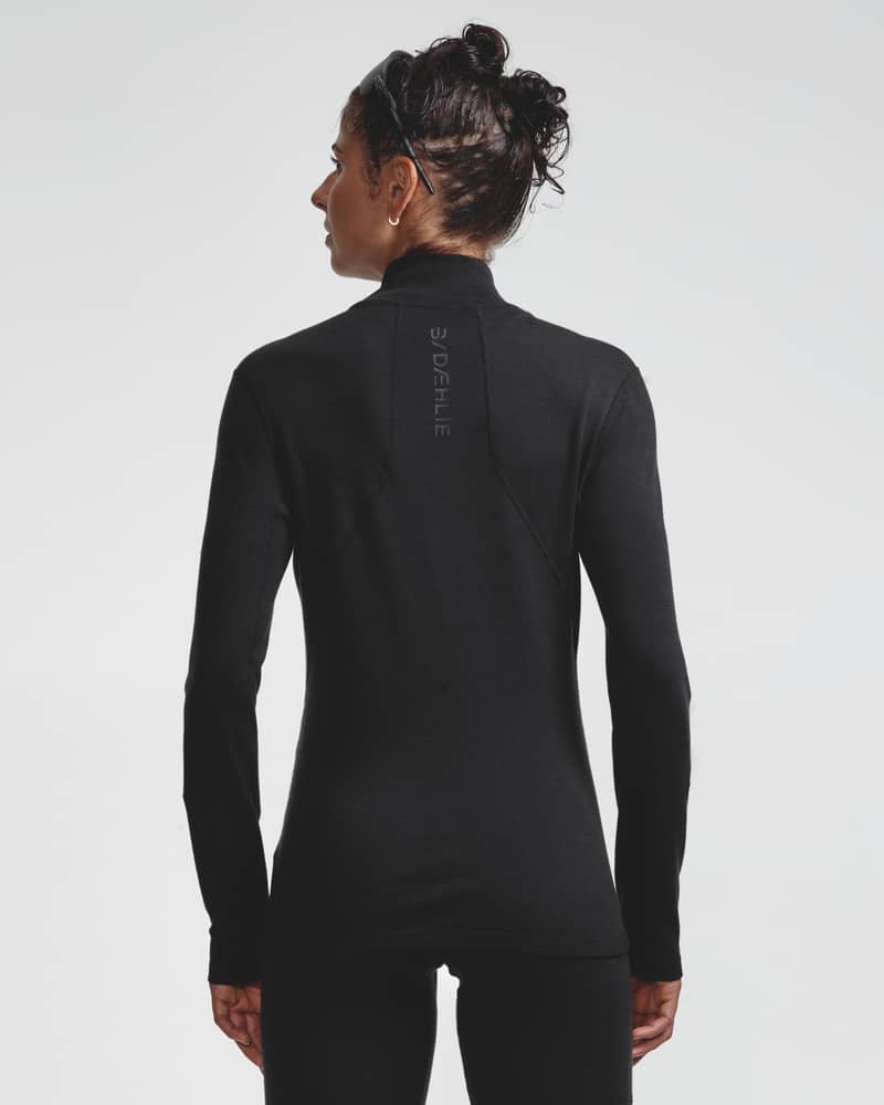 Dæhlie female model wearing black half-zip baselayer top, back view.
