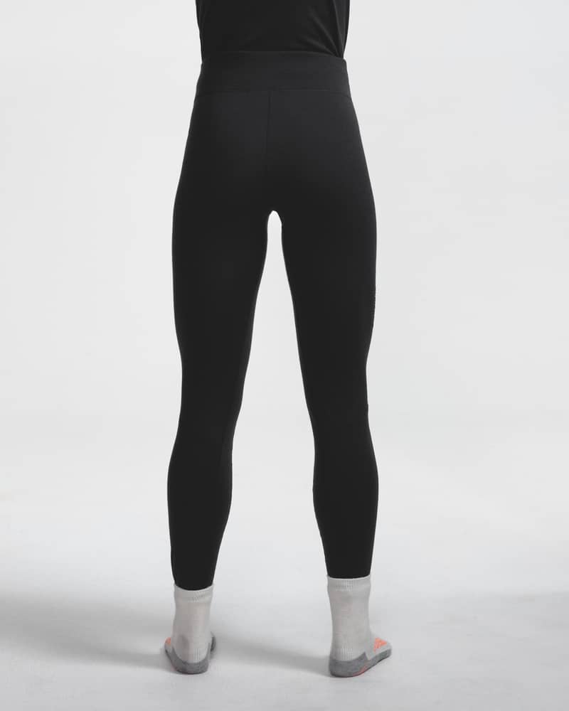 Dæhlie female model wearing black baselayer leggings, back view close-up.