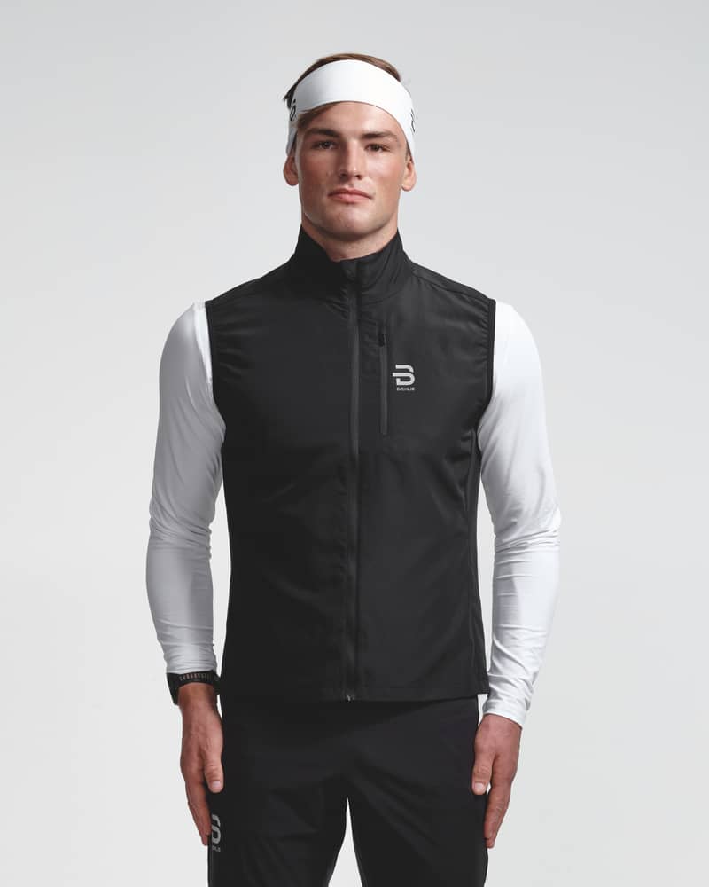 Dæhlie male model wearing black sleeveless running vest, front view.